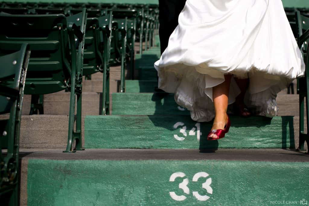 a bride and groom walking down the steps of a stadium.