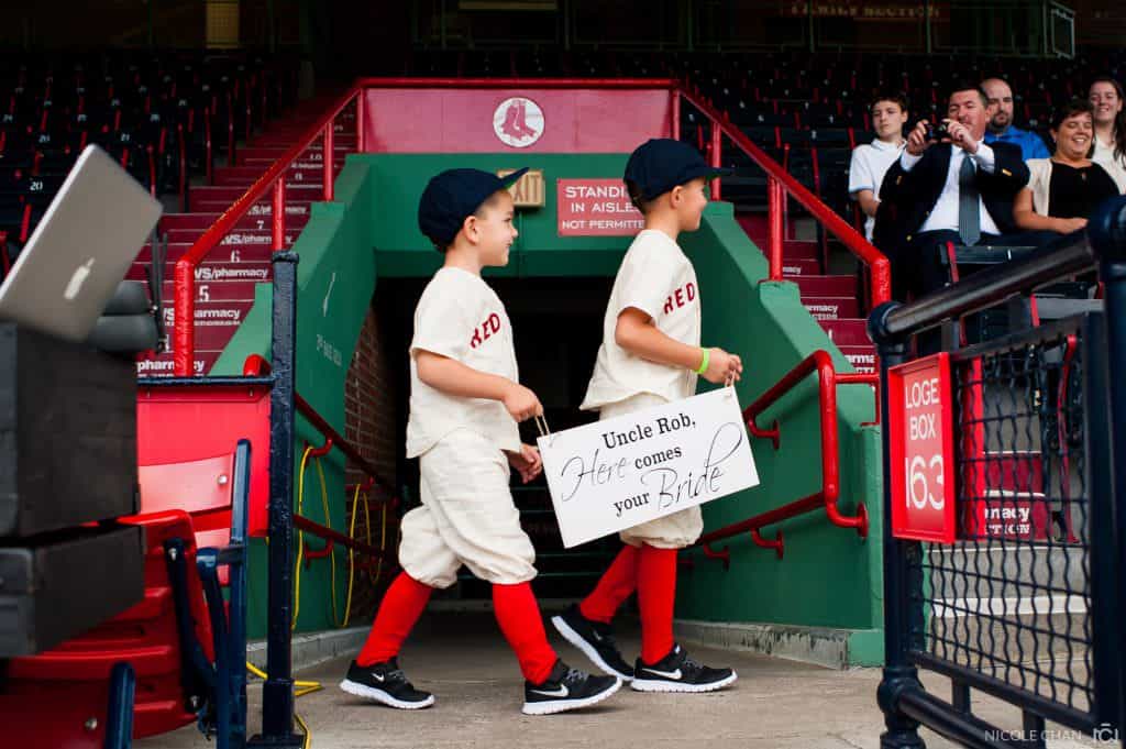 two young baseball players walking out of a dugout.