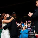 a bride and groom hug each other in front of a crowd.