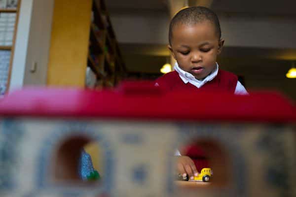 a young boy playing with a toy truck.
