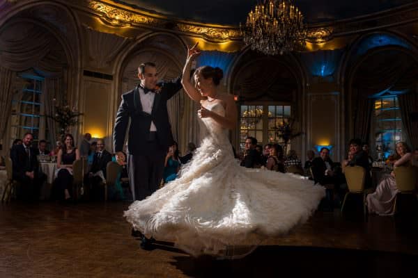 a bride and groom dancing in a ballroom.