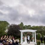 a bride and groom standing under a wedding arch.