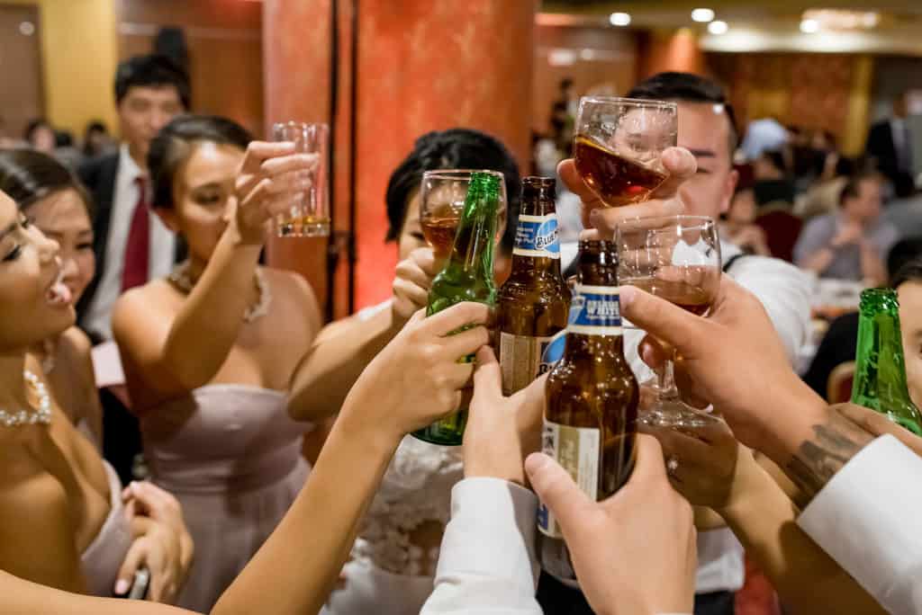 a group of people are toasting with beer.