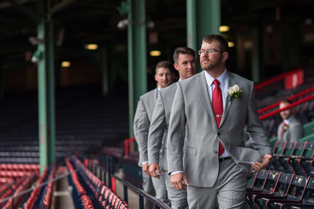 a group of men in suits walking down a baseball field.