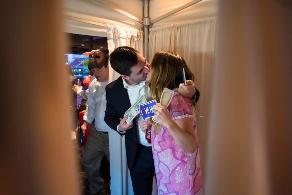 a man and a woman kissing in front of a mirror.