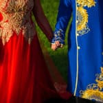 a man and a woman dressed in red and blue holding hands.
