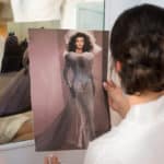 a woman looking at a picture of a woman in a wedding dress.