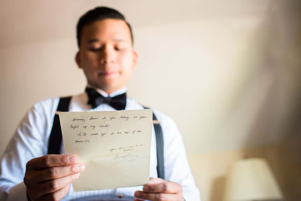a man in a bow tie holding a piece of paper.