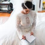 a woman in a wedding dress holding a pen.