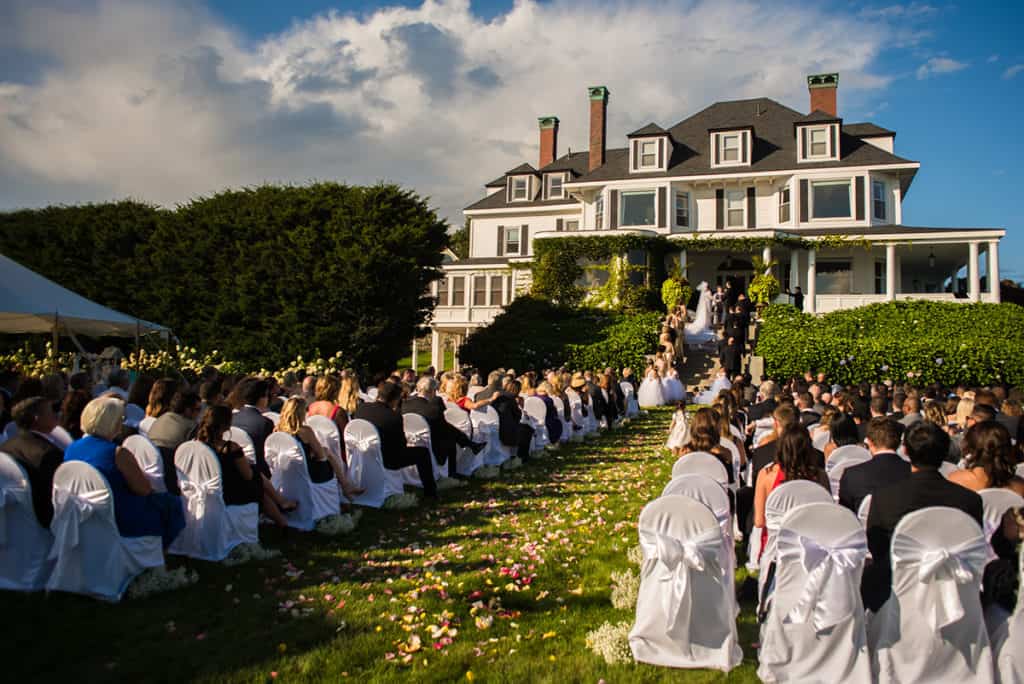 a wedding ceremony in front of a large house.