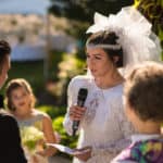 a woman in a wedding dress holding a microphone.