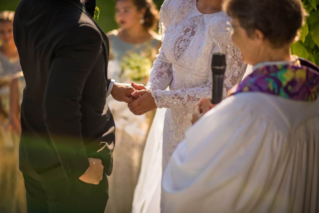 a bride and groom holding hands during a wedding ceremony.