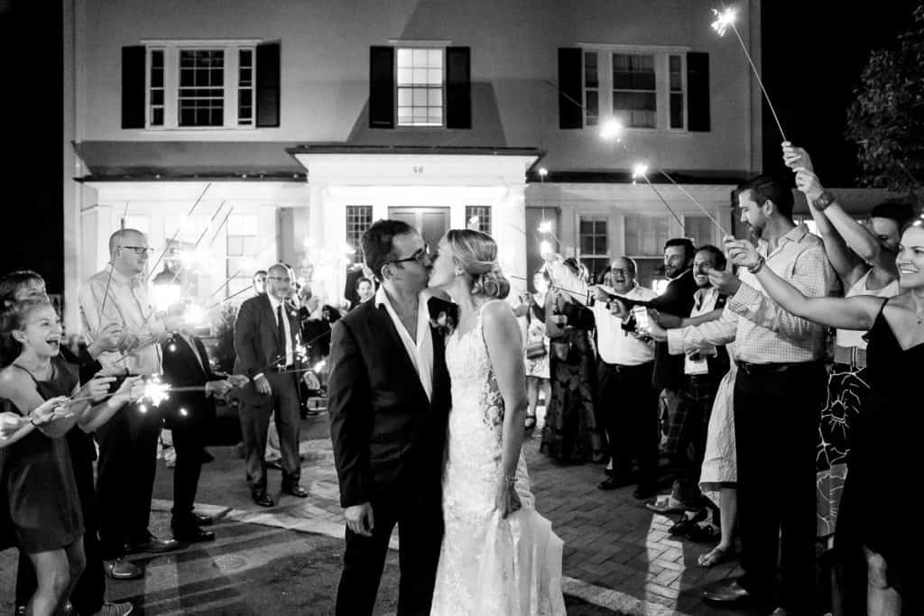 a bride and groom kissing in front of a crowd of people.