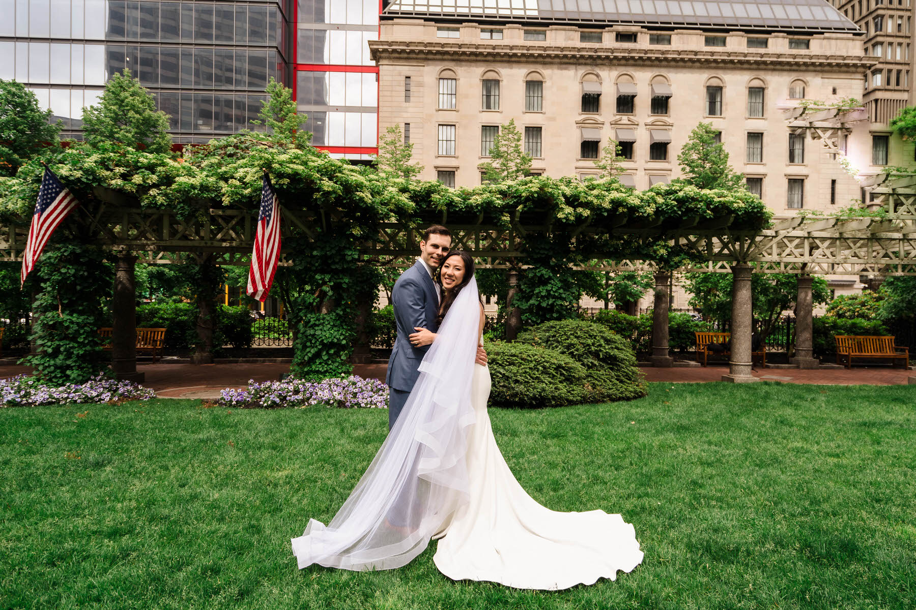 a bride and groom pose in front of a building.