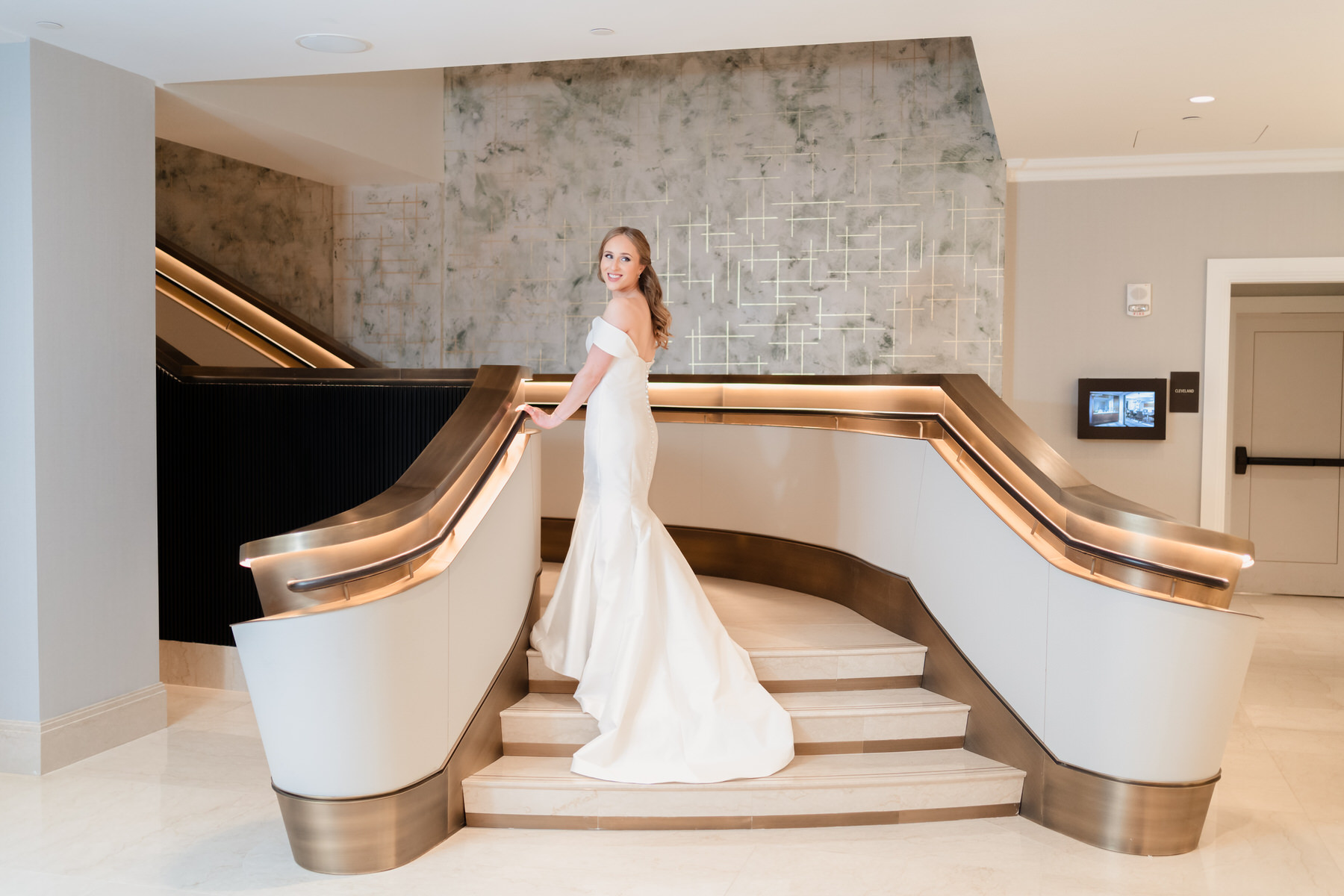 a woman in a wedding dress standing on a staircase.