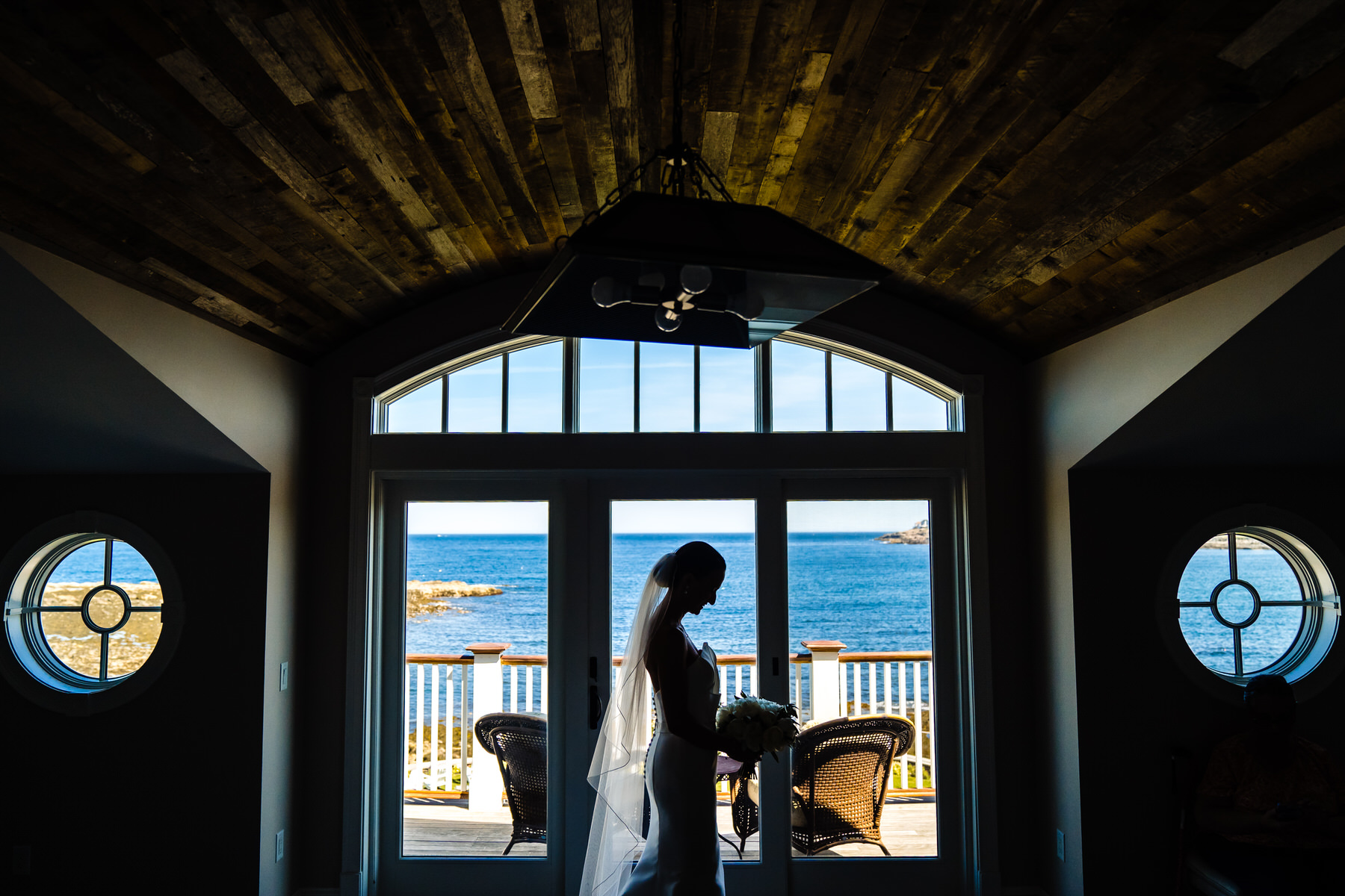 a bride standing in front of a large window.