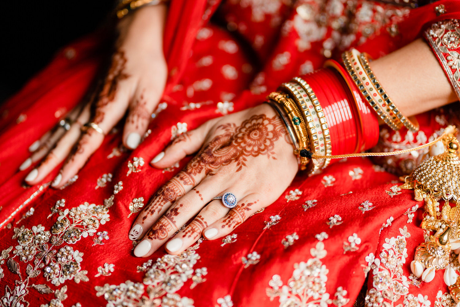a close up of a woman's hands with henna and jewelry.