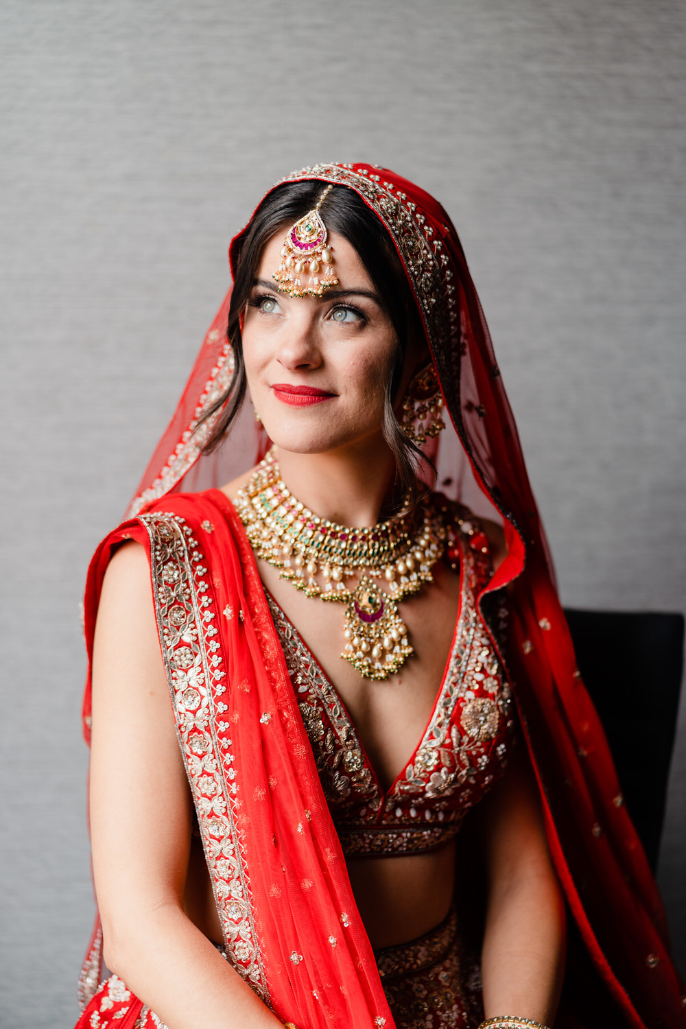 a woman in a red and gold bridal outfit.