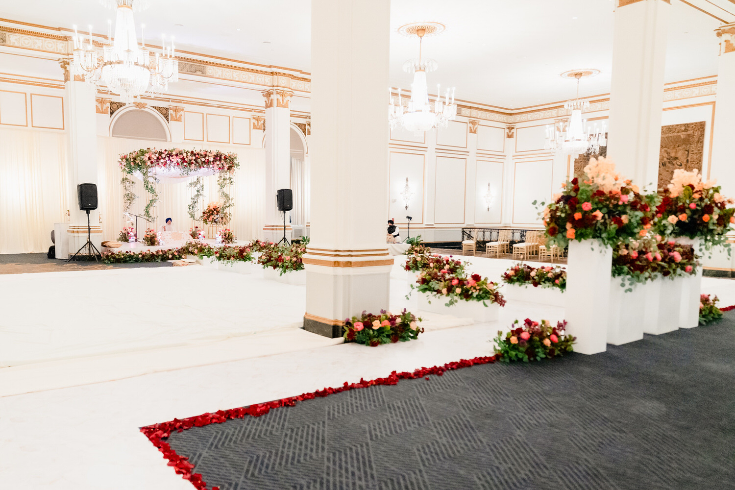 a wedding ceremony with flowers on the floor.