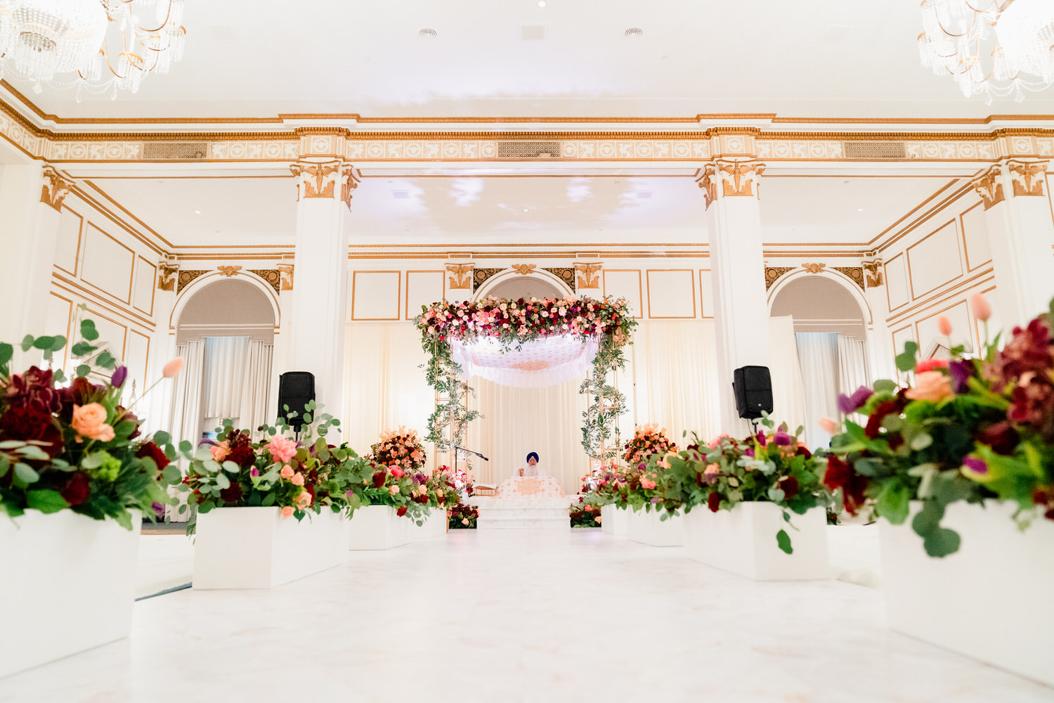 a white room with flowers and a chandelier.