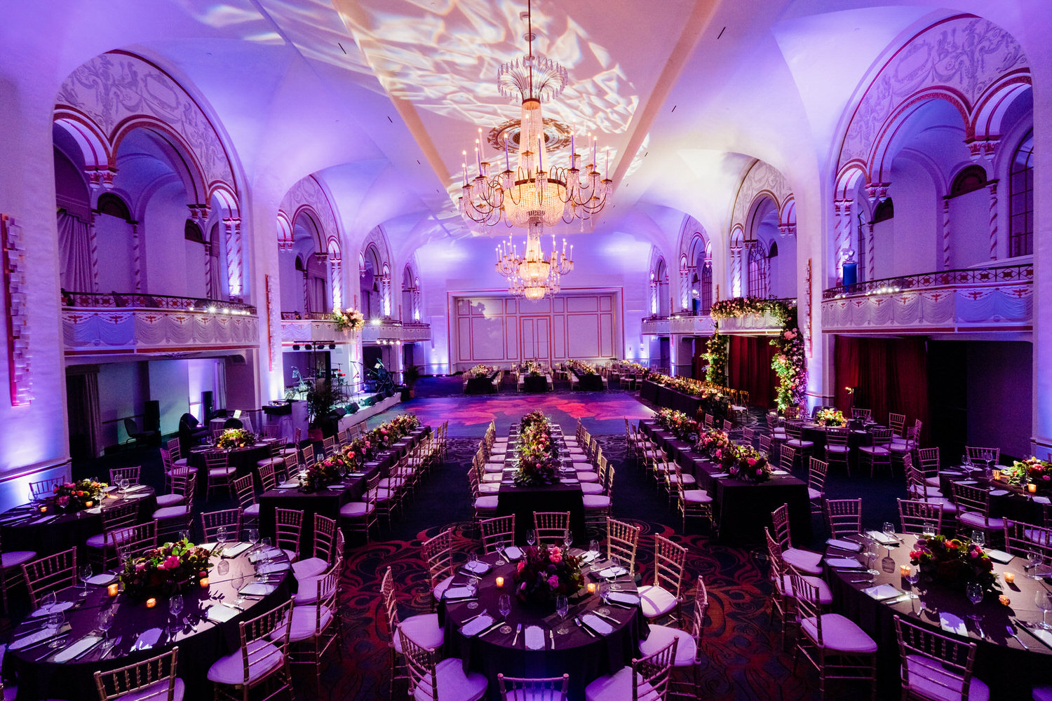 a banquet hall with tables and chairs and a chandelier.