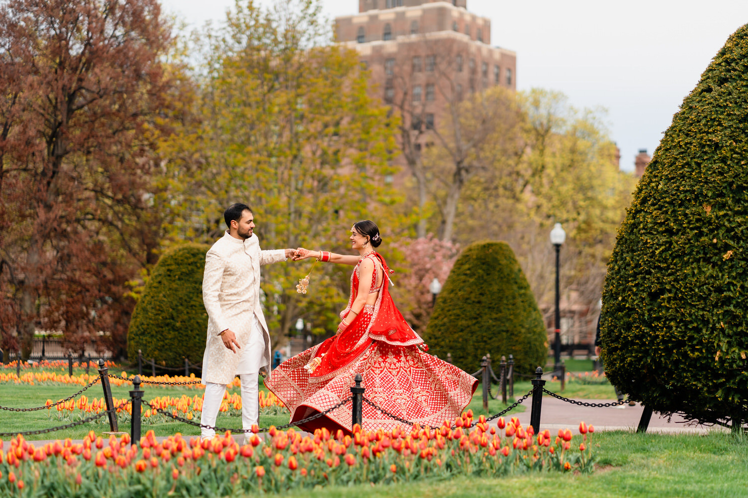 a man and woman dressed in traditional indian garb dancing in a park.