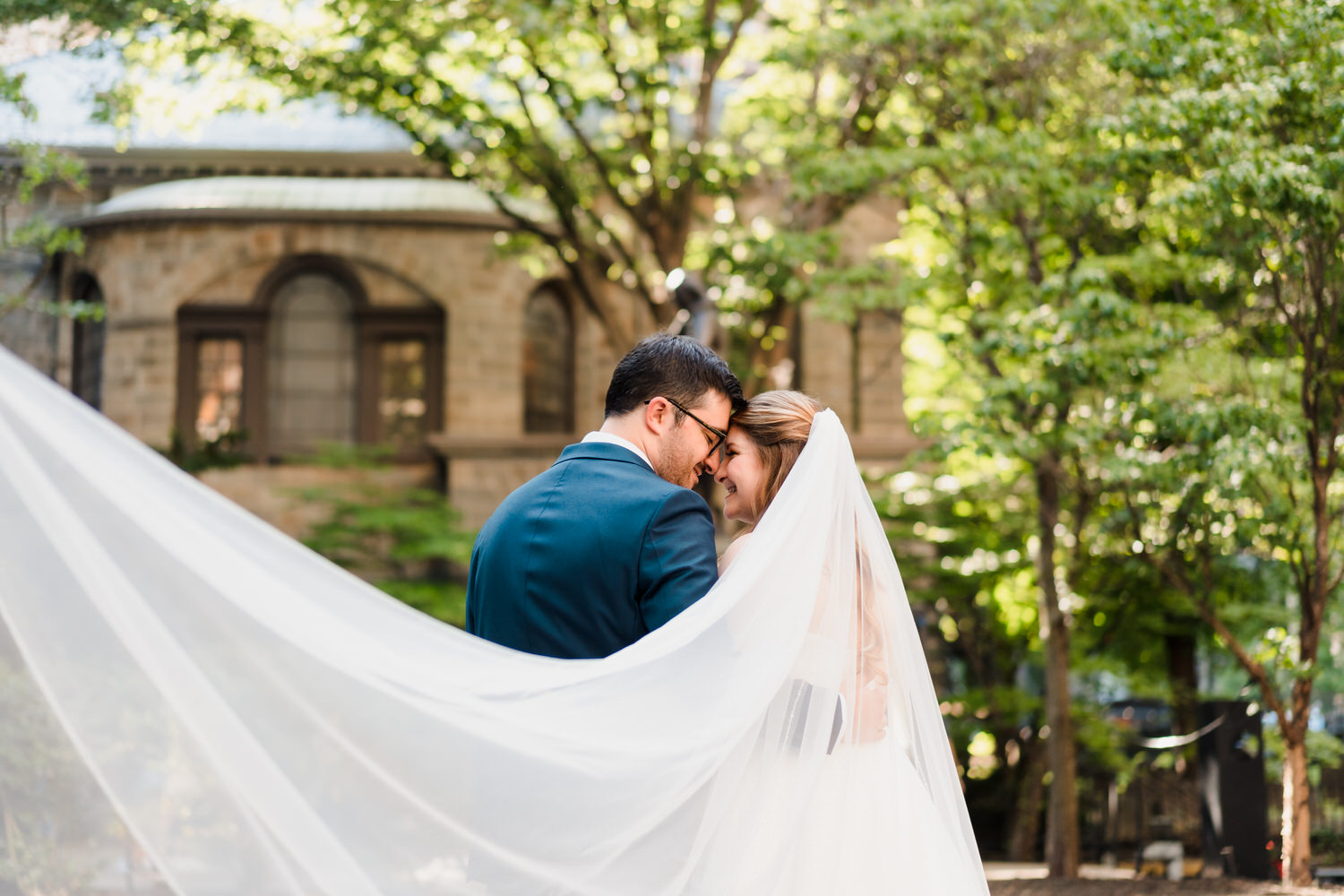 a man and woman kissing under a veil.