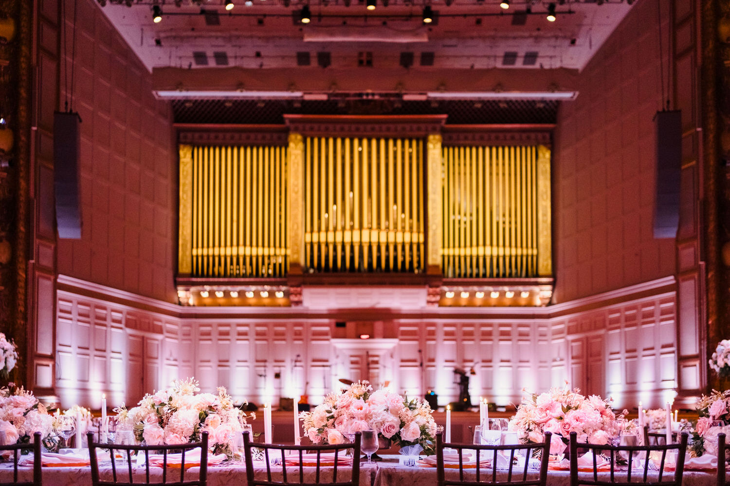 A wedding reception set up in a large room with a large organ.
