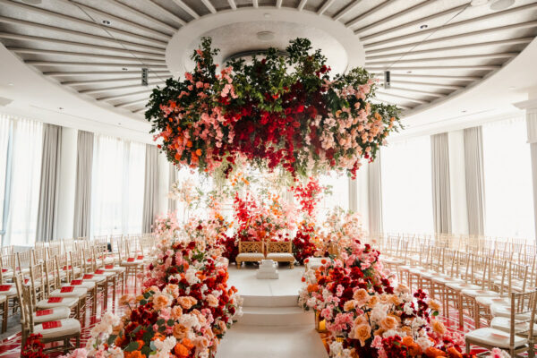 A wedding ceremony with flowers hanging from the ceiling.