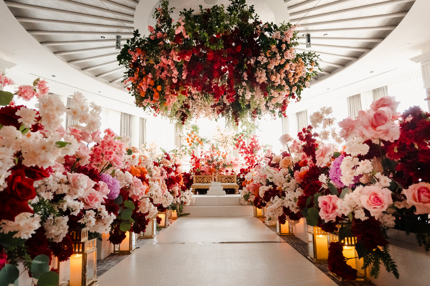A wedding ceremony with flowers hanging from the ceiling.