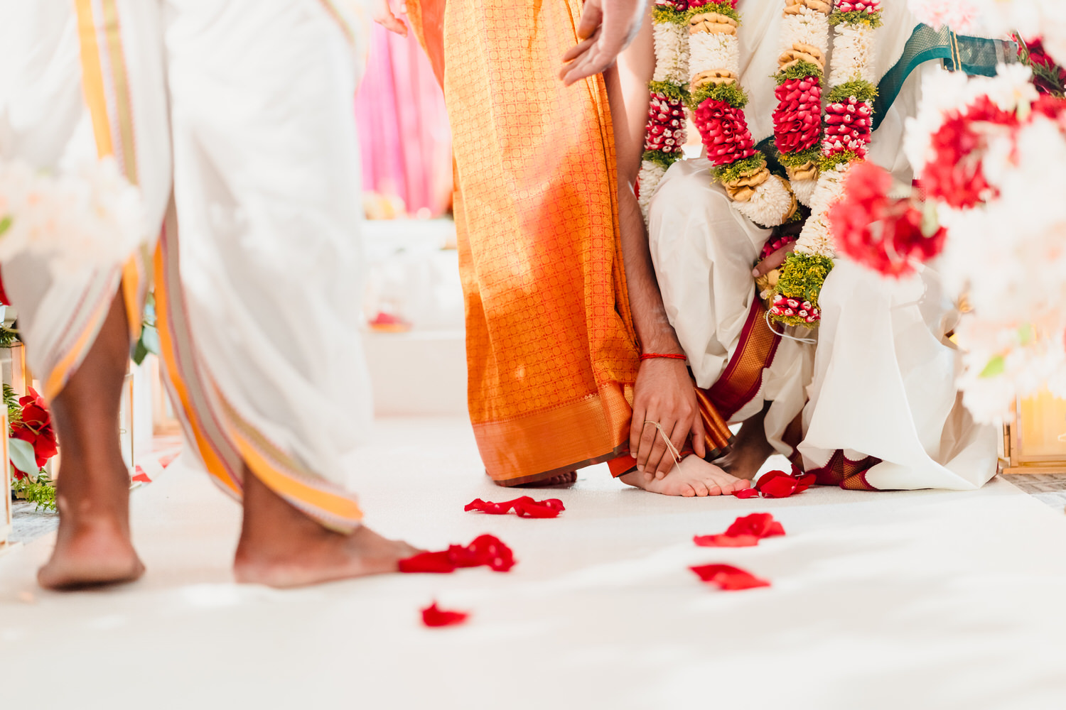 An indian wedding ceremony with flowers on the floor.