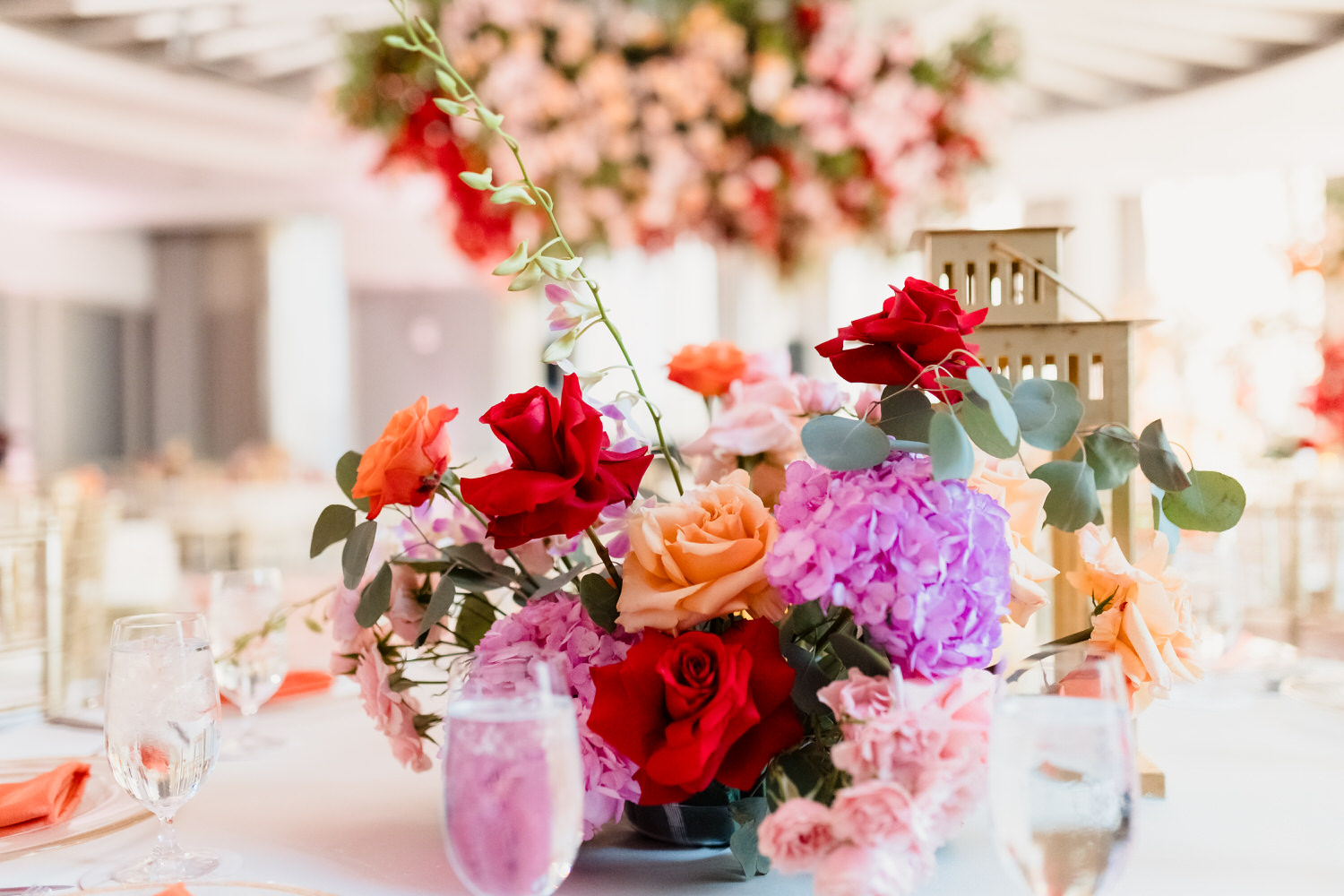 A colorful floral arrangement on a table at a wedding reception.