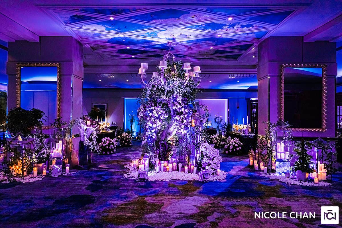 A wedding reception set up with purple and blue lighting.