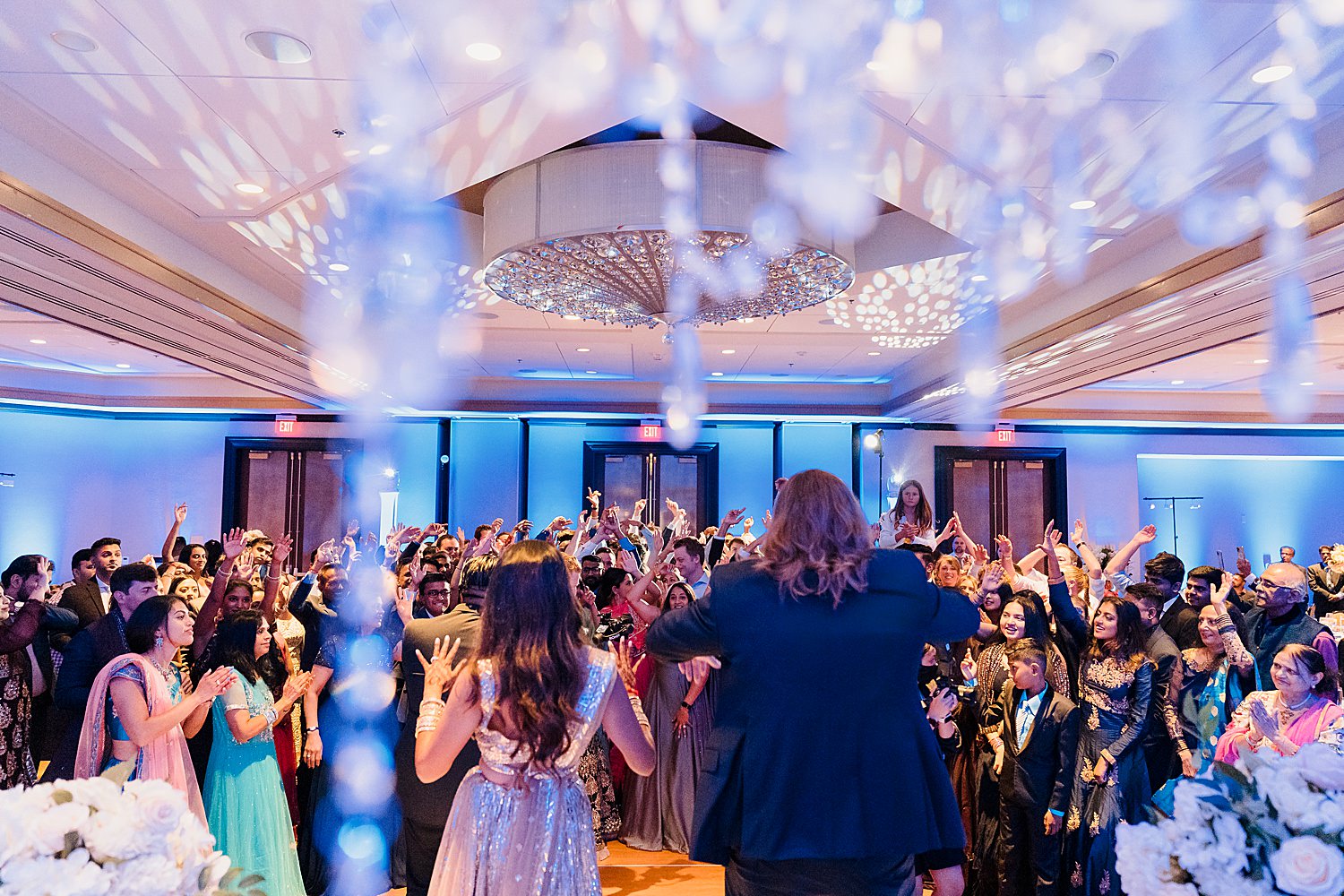 A wedding reception with people dancing in the middle of the room.