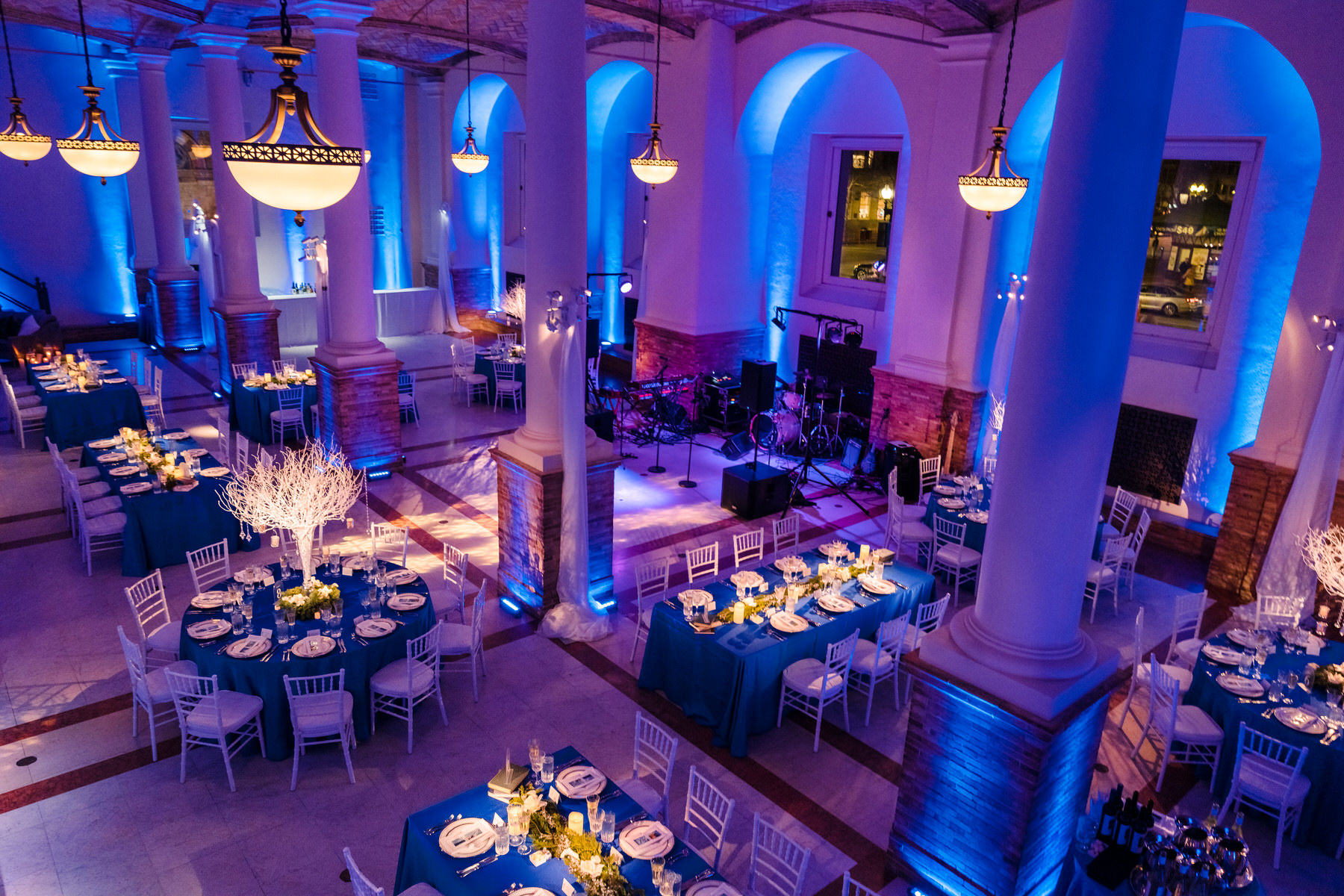 A room with tables and chairs and blue lights.